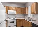Functional kitchen features wood cabinets, essential white appliances, and a double sink at 2929 W Yorkshire Dr # 2074, Phoenix, AZ 85027