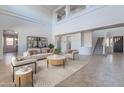 Bright living room featuring high ceilings, a modern staircase and neutral decor, creating an inviting atmosphere at 30277 N 125Th Ln, Peoria, AZ 85383
