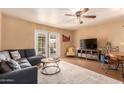 Comfortable living room featuring a ceiling fan, a gray sofa, and glass paneled french doors at 3031 E Avalon Dr, Phoenix, AZ 85016