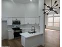 Modern kitchen featuring white cabinets, stainless steel appliances, quartz countertops, and a stylish island at 3440 E Southern Ave # 1107, Mesa, AZ 85204