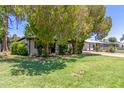 Charming single-story home surrounded by mature trees and a lush green lawn at 3526 E Cheery Lynn Rd, Phoenix, AZ 85018