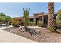 Landscaped front yard with cacti, boulders, desert plants add visual interest to this desert home at 42310 W Fountainhead St, Maricopa, AZ 85138
