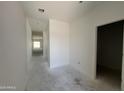 Bright hallway with crisp white walls and concrete floors leads to a room with plenty of natural light at 47706 W Moeller Rd, Maricopa, AZ 85139