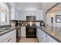 Well-lit kitchen featuring white cabinets, stainless steel appliances, and elegant granite countertops at 6138 N 28Th St, Phoenix, AZ 85016