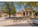 Charming home with a desert landscape and a two-car garage at 7169 S Dodane Ct, Gilbert, AZ 85298