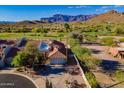 Expansive desert home with a tile roof, lush desert landscaping, and views of the nearby golf course at 8950 E Greenview Dr, Gold Canyon, AZ 85118