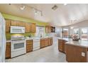 Well-lit kitchen featuring tile flooring, neutral walls and countertops, wood cabinets, and bright white appliances at 9175 E Rainier Dr, Gold Canyon, AZ 85118