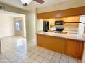 View of kitchen with black appliances, tile backsplash, and light wood cabinets at 924 S Hacienda Dr # C, Tempe, AZ 85281