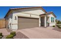 Beautiful single-level home with a brick driveway, brown garage door, and desert-friendly landscaping at 17506 W Hadley St, Goodyear, AZ 85338