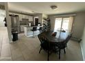 Open-concept dining area flowing into the kitchen with an island bar and stainless steel appliances at 2007 N 55Th Ln, Phoenix, AZ 85035