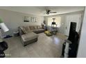 Inviting living room with tile floors, a cozy sectional sofa, neutral walls and a cat tree for furry friends at 2007 N 55Th Ln, Phoenix, AZ 85035
