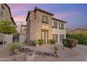 Charming two-story home with stone accents, two-car garage, and desert landscaping in the front yard at 22317 N 39Th Run, Phoenix, AZ 85050