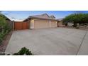 Spacious driveway leading to a three-car garage, complemented by a secure gated area on the side at 2434 S Colleen Sw --, Mesa, AZ 85210