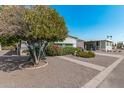 Landscaped front yard with mature tree offering shade in this mobile home community at 2650 W Union Hills Dr # 164, Phoenix, AZ 85027