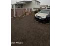 Compact home, including a gravel yard, privacy fence, and space for parking at 2721 E Beverly Ln, Phoenix, AZ 85032