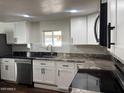 Contemporary kitchen design with sleek white cabinets, stainless appliances, and granite countertops at 2721 E Beverly Ln, Phoenix, AZ 85032