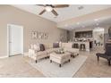 Bright living room featuring neutral tones, a plush sectional sofa, and a ceiling fan at 30390 W Mitchell Ave, Buckeye, AZ 85396