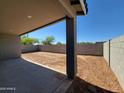 View of a spacious backyard with a concrete patio, block wall, and freshly tilled soil ready for landscaping at 37357 W San Sisto Ave, Maricopa, AZ 85138