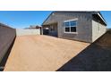 Large backyard with covered patio, block wall, and expansive dirt area awaiting your landscaping ideas at 37357 W San Sisto Ave, Maricopa, AZ 85138