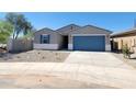 Single-story home with a blue garage door, xeriscaped front yard, and desert landscaping under a bright blue sky at 37357 W San Sisto Ave, Maricopa, AZ 85138