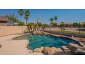 A relaxing backyard swimming pool surrounded by mature palm trees at 3765 E Oxford Ln, Gilbert, AZ 85295