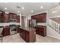 Kitchen features stainless steel appliances, granite countertops, tile flooring, and a view of the stairs at 4322 S Ranger Trl, Gilbert, AZ 85297