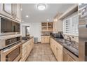 Updated kitchen features stone floors, granite countertops, stainless steel appliances, and recessed lighting at 5307 N 32Nd Pl, Phoenix, AZ 85018