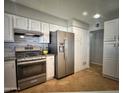 Bright kitchen featuring stainless steel appliances, white cabinets, and tile flooring at 6111 N 64Th Dr, Glendale, AZ 85301