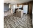Open kitchen with stainless steel appliances, an island, and wood-look tile floors at 625 W Mckellips Rd # 111, Mesa, AZ 85201