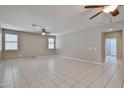 Bright living room featuring tiled floors, a ceiling fan and multiple windows at 6833 W Tether Trl, Peoria, AZ 85383