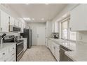Bright kitchen featuring white cabinetry, stainless steel appliances, and a window over the sink at 9814 W Long Hills Dr, Sun City, AZ 85351