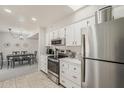 Stylish kitchen with white cabinets and stainless steel appliances open to the dining area at 9814 W Long Hills Dr, Sun City, AZ 85351