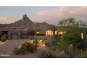 Desert home with a three-car garage, complemented by lush desert landscaping and mountain views at 10040 E Happy Valley Rd # 1011, Scottsdale, AZ 85255