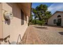Paver walkway along the side of the home, surrounded by desert landscaping and lush greenery at 13731 W Greenview Dr, Sun City West, AZ 85375