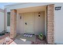 Inviting home entry featuring covered porch with brick supports and a secure screen door at 14080 N Newcastle Dr, Sun City, AZ 85351