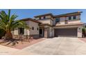 Stucco two-story home featuring a desert-landscaped yard, covered porch, and two-car garage at 1446 E Douglas St, Casa Grande, AZ 85122