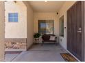 Cozy covered porch with a window, bench seating, stone accents, and a decorative welcome mat at 1446 E Douglas St, Casa Grande, AZ 85122