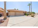 Spacious three-car garage and long driveway, complemented by desert landscaping and a stone accented facade at 1625 W Gunstock Loop, Chandler, AZ 85286