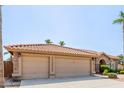 Three-car garage with stone accents and desert landscaping under a red tile roof, exemplifying southwest charm at 1625 W Gunstock Loop, Chandler, AZ 85286