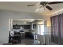 This spacious kitchen features dark cabinetry and a modern ceiling fan at 17335 W Woodlands Ave, Goodyear, AZ 85338
