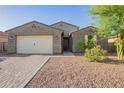Inviting single-story home with a well-maintained front yard and a two-car garage at 18630 W Lawrence Ln, Waddell, AZ 85355
