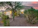 Single-story home showcasing desert landscaping and a quaint front facade at dusk at 18630 W Lawrence Ln, Waddell, AZ 85355