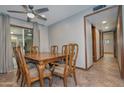 Dining room with ceiling fan and light, sliding glass door and wooden table with chairs at 228 N 65Th Pl, Mesa, AZ 85205