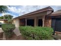 Brick single-story home exterior featuring manicured landscaping and a cozy covered porch at 2320 W El Alba Way, Chandler, AZ 85224