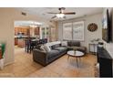 Comfortable living room with a large window, ceiling fan and seamless flow into the kitchen at 2331 E Sunland Ave, Phoenix, AZ 85040