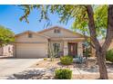Attractive single-story home showcasing desert landscaping, stone accents, and an attached two car garage at 2409 W Red Range Way, Phoenix, AZ 85085