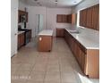 A spacious kitchen featuring stainless steel appliances, an island, and tile flooring at 26022 N Sandstone Way, Surprise, AZ 85387
