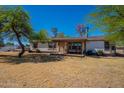 Well-maintained single-story home with a covered front porch and a large, sunny front yard at 3738 E Hash Knife Draw Rd, Queen Creek, AZ 85140
