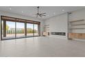 Bright living room with fireplace, tile floors, and large sliding glass doors to backyard at 39302 N 30Th Dr, Phoenix, AZ 85086