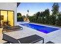 Backyard pool featuring a tanning ledge, surrounded by lush landscaping and lounge chairs for relaxation at 4002 N 33Rd Pl, Phoenix, AZ 85018